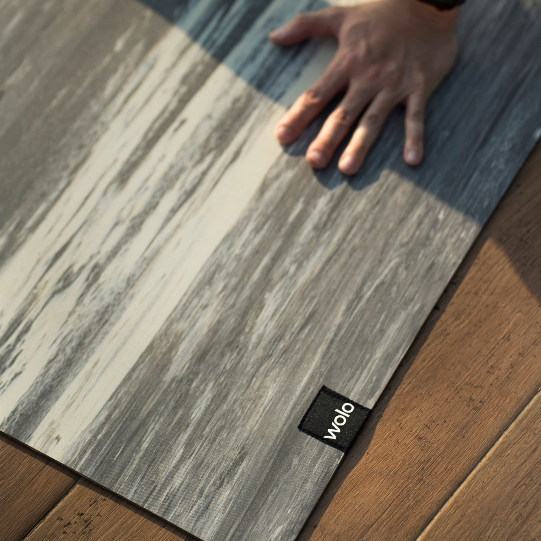 Wooden floor with a hand touching grey yoga mat#color_limestone grey