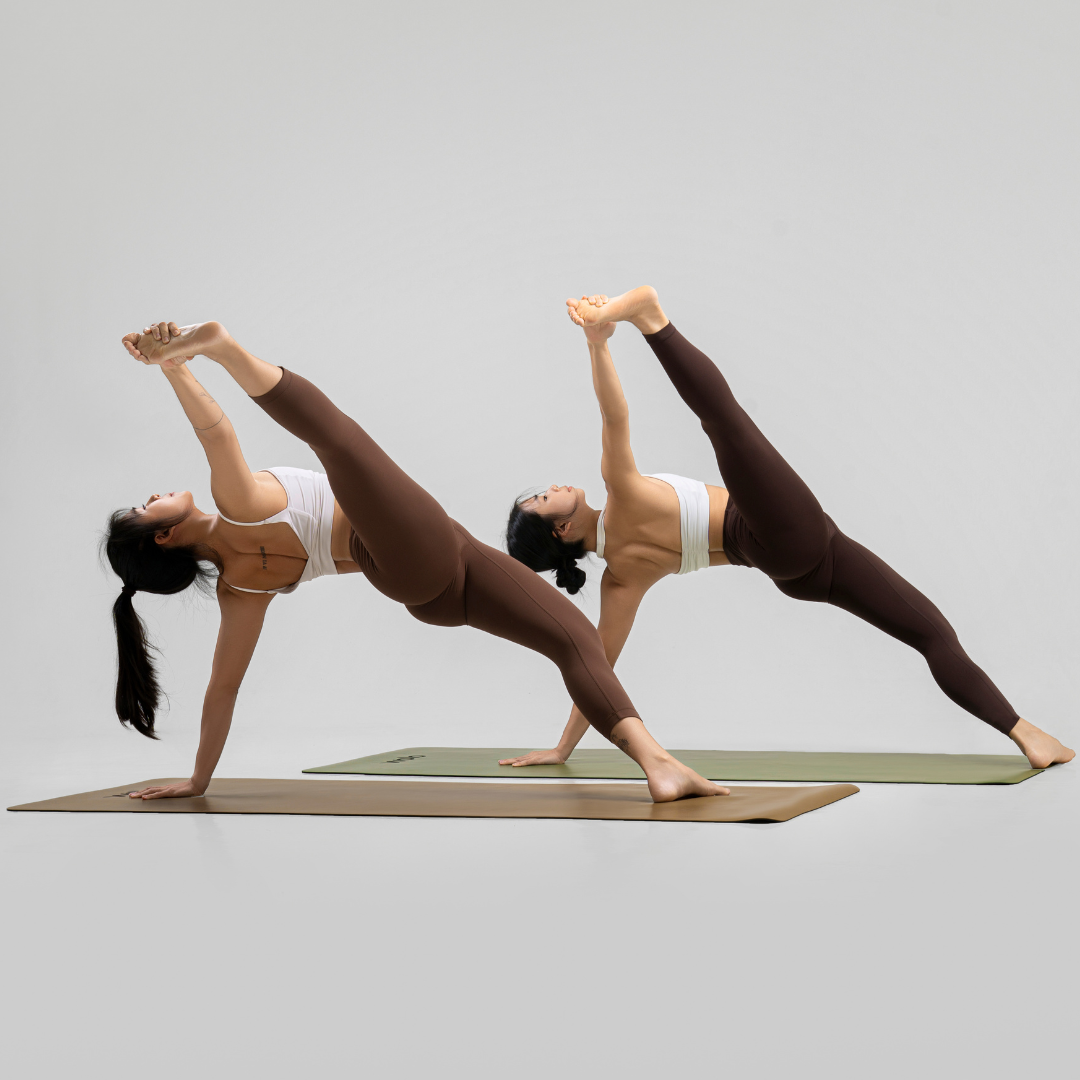 Two women performing a yoga pose side plank hand to big toe on Wolo Mastery Yoga Mats