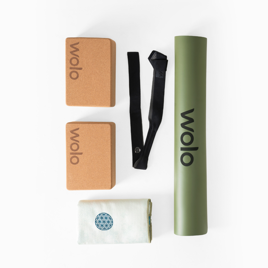 Wolo Yoga accessories including a cork block, strap, mat, and towel on a white background.