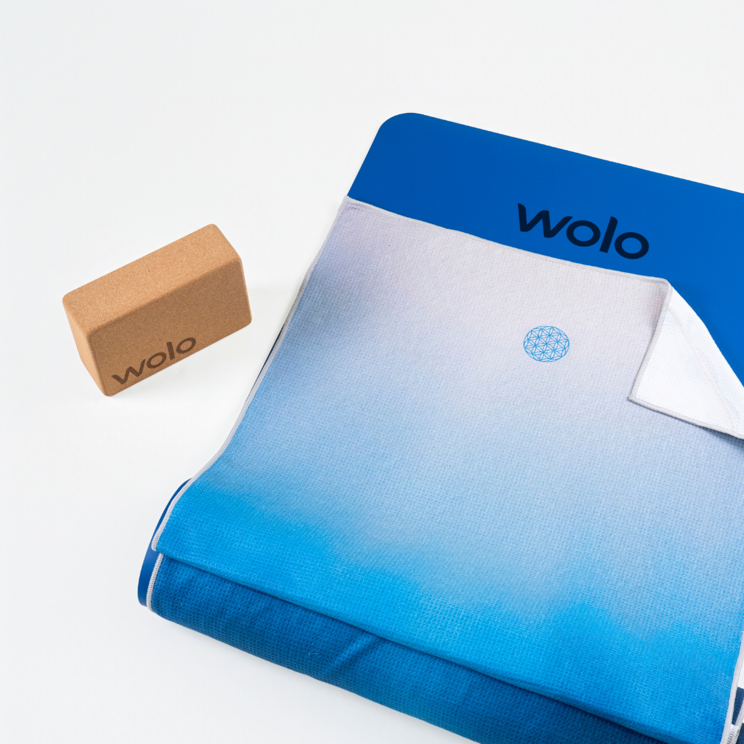 Blue and gray gradient yoga mat with a brown yoga block on a white background, featuring the 'wolo' brand.