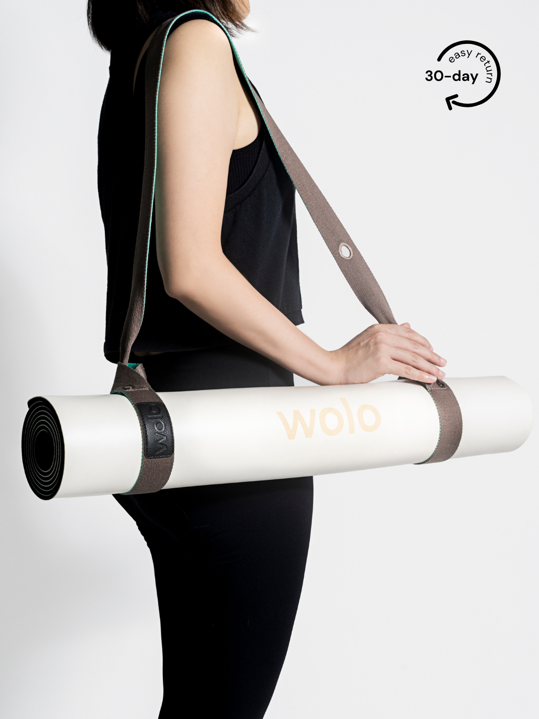Lady carry a white yoga mat with a mint green mat carry strap