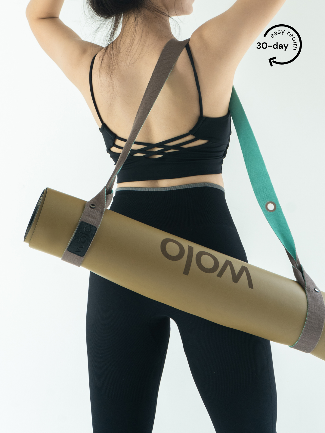 Lady carry a khaki yoga mat with a mint green mat carry strap