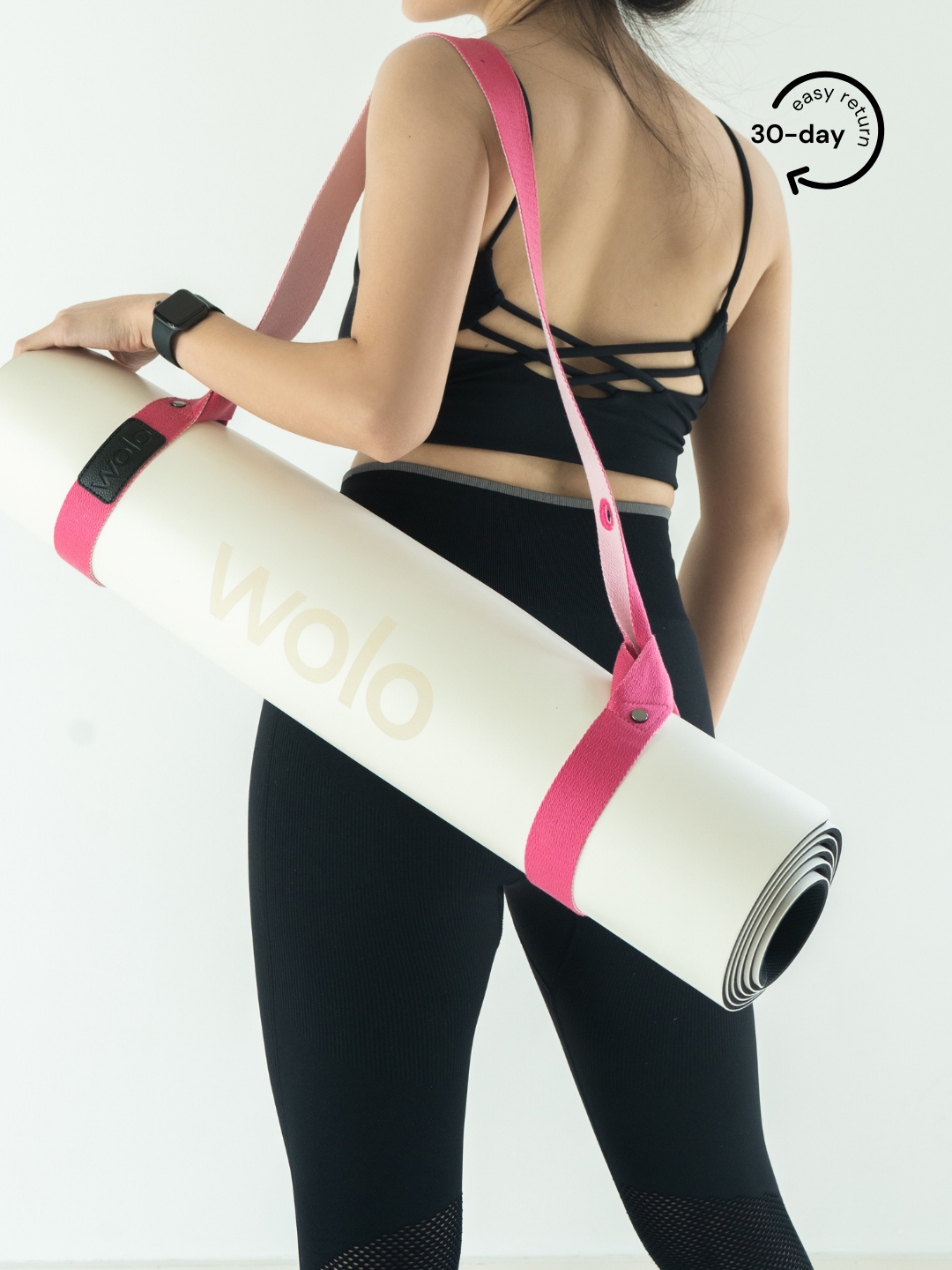 Lady carry a white yoga mat with a pink mat carry strap