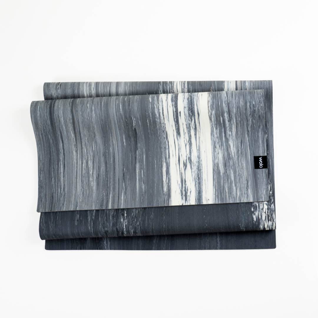 Folded gray and white patterned yoga mat with a brand logo on a white background#color_limestone grey