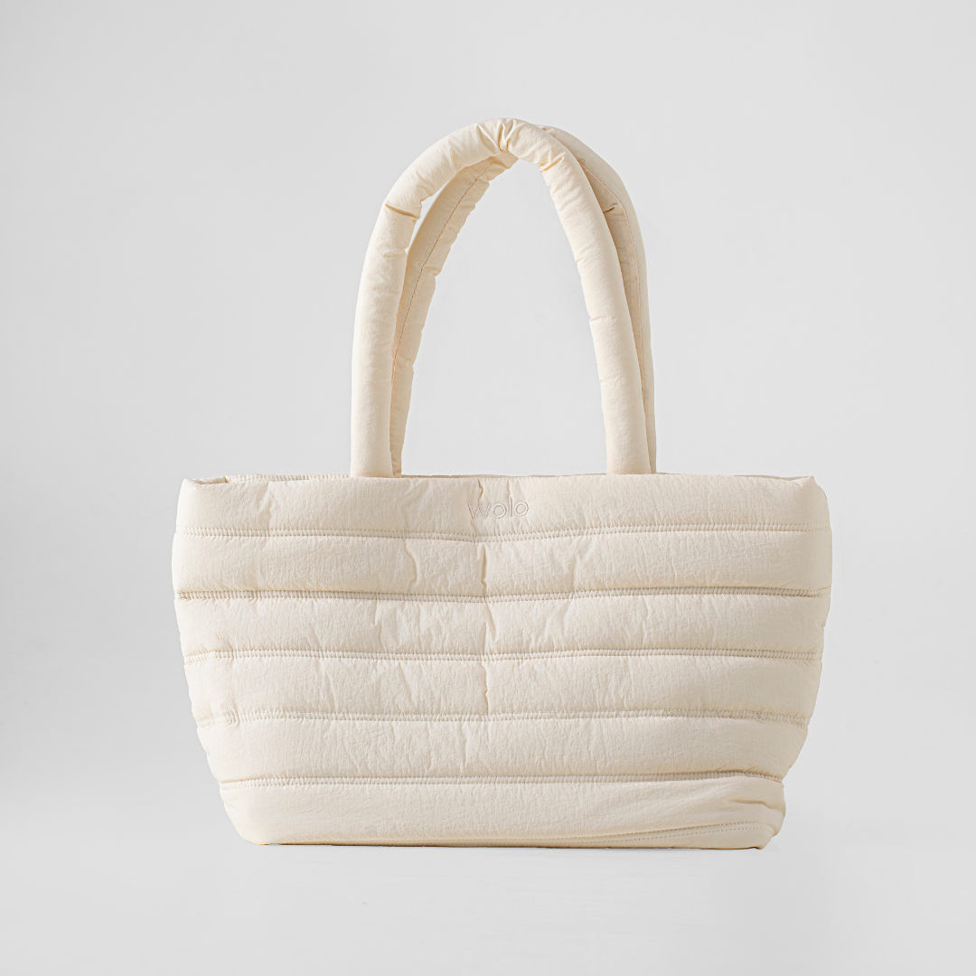 Beige quilted handbag on a light gray background#color_linen cream