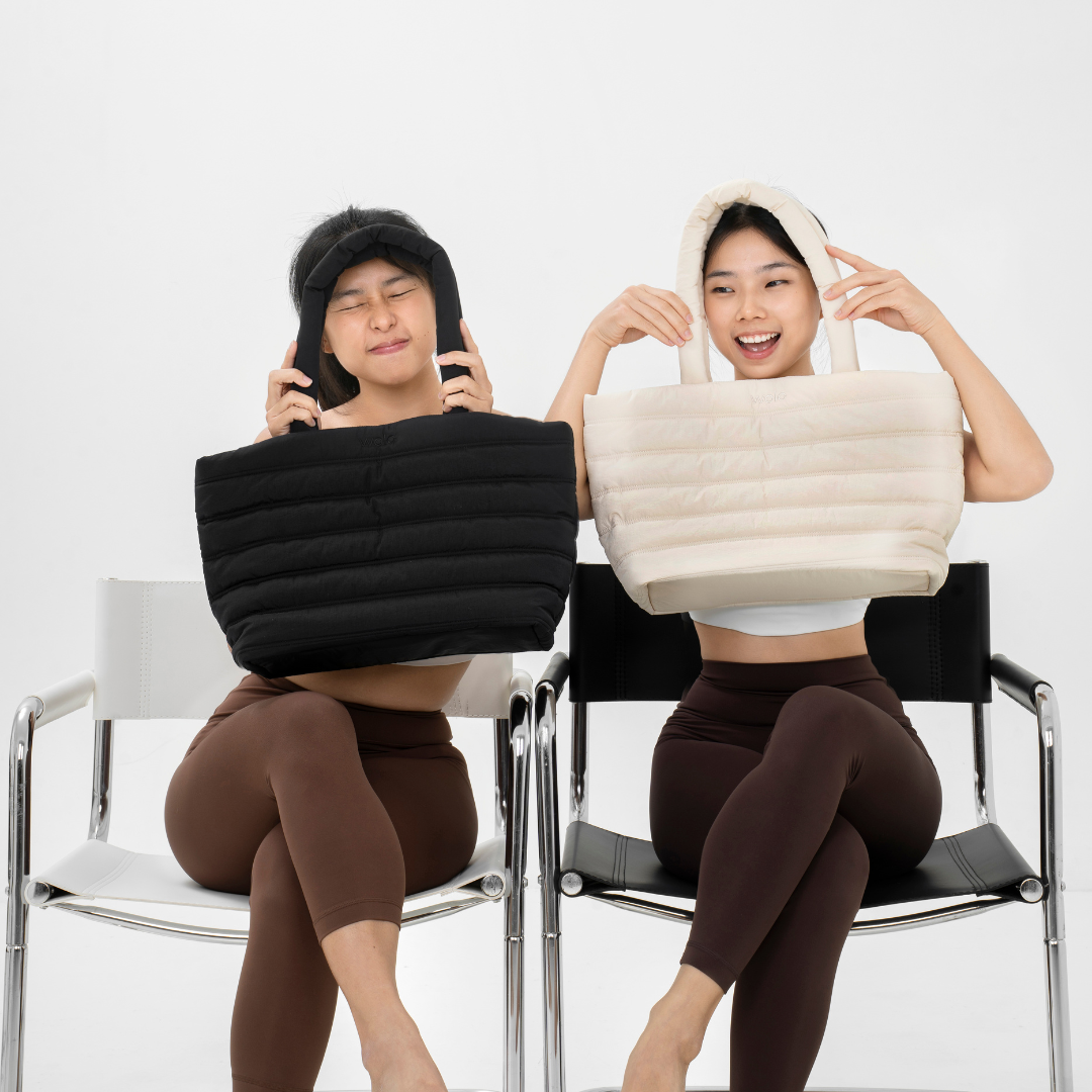 Two people sitting on chairs with puffer tote bags over their heads
