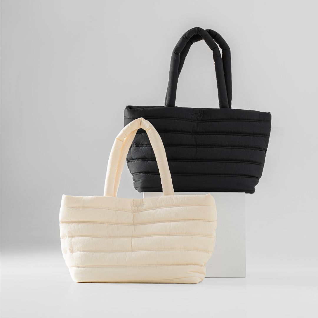 Black and beige quilted handbags on a light gray background