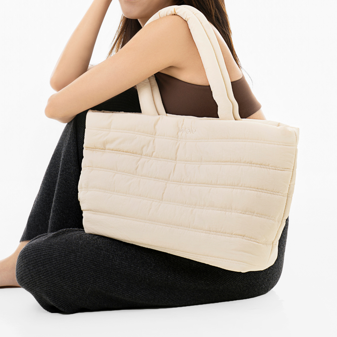 Person holding a quilted beige tote bag#color_linen cream
